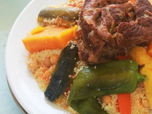 Couscous marocain à la viande et aux sept légumes Cette recette exceptionnelle de couscous classique de style Casablanca comprend du couscous cuit à la vapeur empilé avec de la viande et des légumes mijotés. (Vous pouvez omettre la viande pour un couscous végétarien.) N'hésitez pas à varier les légumes selon les préférences de votre famille, mais essayez d'inclure une variété complète pour obtenir une sauce au goût authentique. Il est devenu de plus en plus populaire ces dernières années de garnir ce plat d'une garniture généreuse de tfaya, un mélange d'oignons caramélisés et de raisins secs qui peut aussi agrémenter le couscous à lui tout seul.