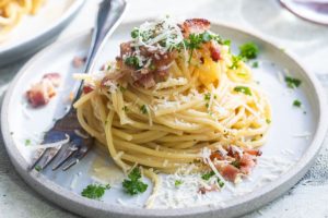 Spaghetti Carbonara Ce plat est une charcuterie œuf-bacon-et-fromage-sur-un-rouleau qui a été transformée en pâtes, fantaisiste, fétichisée et transformée en une tradition italienne qui, comme de nombreuses traditions italiennes inviolées, est en fait beaucoup moins ancienne que le Mayflower . Parce que l'Amérique a peut-être contribué à sa création, la carbonara est la pièce A du va-et-vient entre l'Italie et les États-Unis en matière de nourriture.