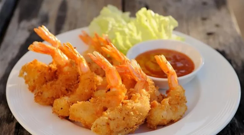 Ces beignets de crevettes sont croustillants à l'extérieur et moelleux et moelleux sur le côté. Ces délicieux morceaux salés sont accompagnés d'un filet de miel épicé qui rend ces beignets de crevettes vraiment irrésistibles.