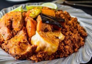 L'origine de la thieboudienne est assez fascinante, mais pas aussi simple qu'on le voudrait car la majeure partie de l'histoire entourant cette délicatesse a été transmise par la tradition orale. Alors que le riz Jollof est traditionnellement attribué à l'Empire wolof sénégalais (qui, du XIVe au XVIe siècle, était un État dirigeant d'Afrique de l'Ouest dont les schémas migratoires ont conduit à la propagation du Jollof à travers l'Afrique de l'Ouest), une perspective populaire est que l'adoption de la thieboudienne comme le Sénégal plat national était le résultat d'une réinvention de l'héritage colonial du Sénégal (ils ont été colonisés par les Français) et de leur culture locale.